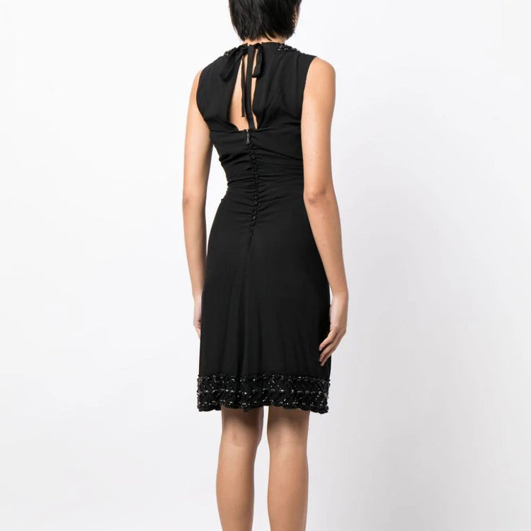 Prada ruched sleeveless dress with a fitted corset-style bodice and elegant design, perfect for stylish occasions.