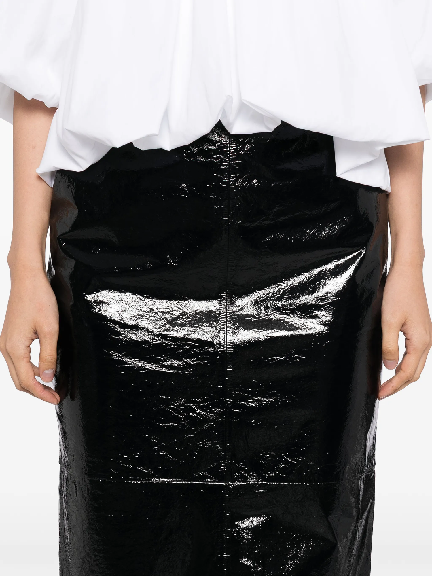 Black leather skirt worn by a person on a white background