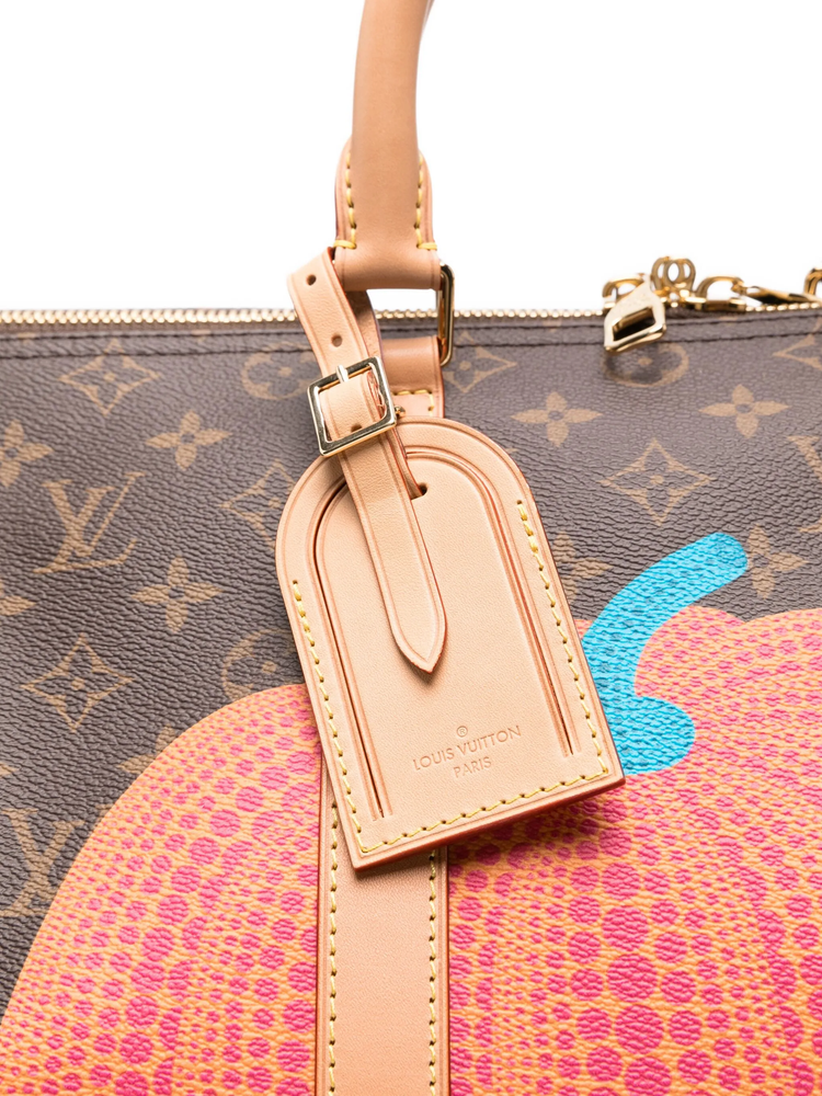 Louis Vuitton monogram handbag with a pink strap and colorful design, featuring a luggage tag.