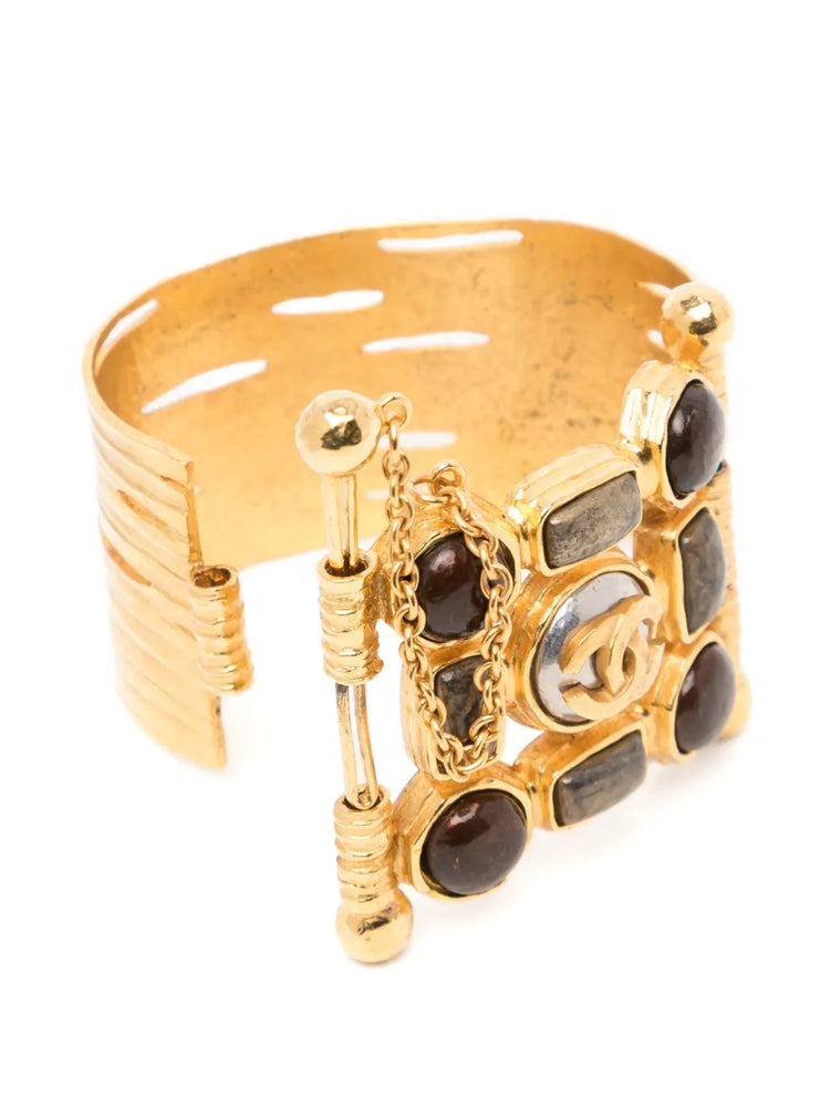 Vintage Chanel wide gold-plated cuff bracelet featuring amber Gripoix glass cabochons and a central frosted medallion with the interlocking CC logo.