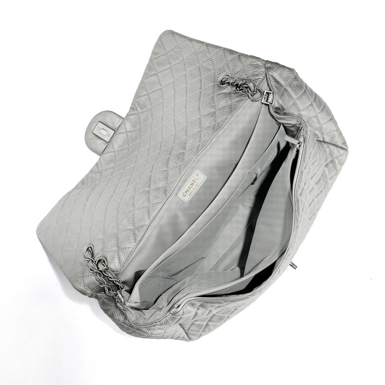 Chanel Metallic silver XXL airline travel flap bag by Rewind Vintage Affairs, showing its shiny surface and spacious design.