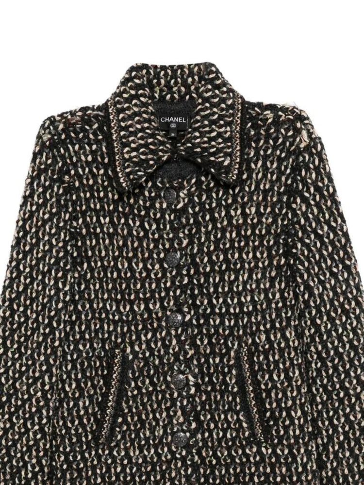 Black Chanel tweed coat with textured fabric and longline design, showcasing classic elegant outerwear.