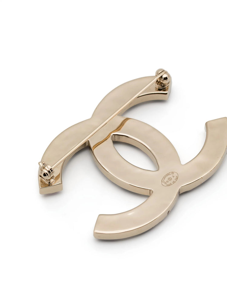 Chanel crystal enamel stripe brooch with colorful designs and gold-tone pin on a white background