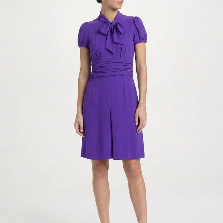 Purple Prada short-sleeve dress with a fitted bodice and flowing skirt, displayed on a hanger against a neutral background.