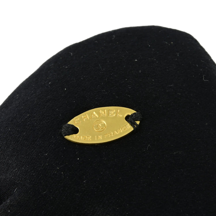 Chanel satin bow brooch featuring a sleek, elegant design with a satin finish and classic bow shape.