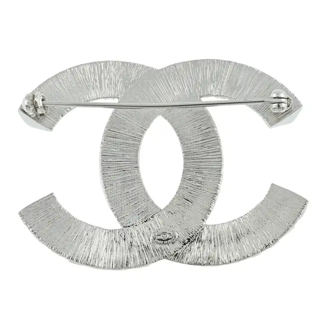 Elegant crystal Chanel pin brooch with intricate design, perfect for adding a touch of luxury to outfits.