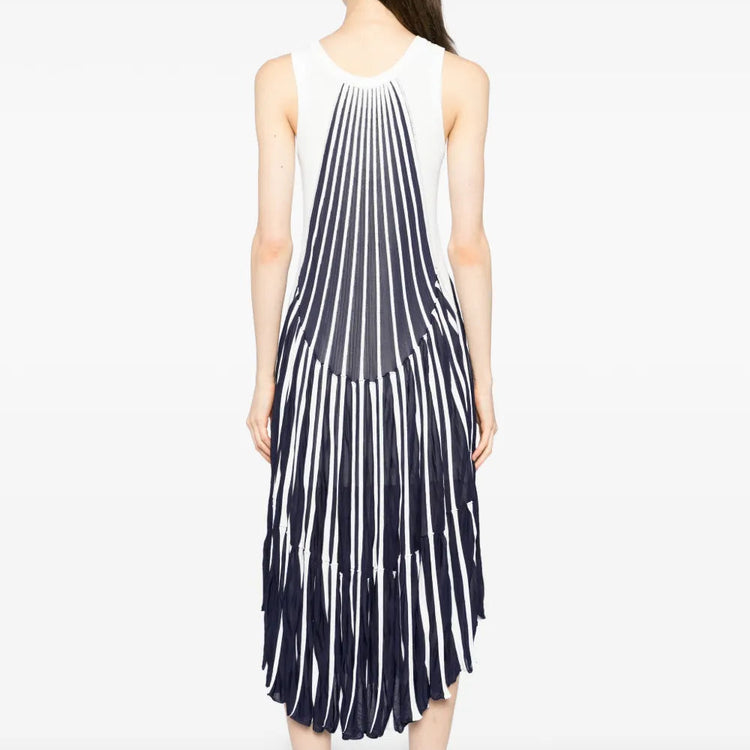 Model wearing a blue and white pleated striped Chloé dress, showcasing the back view with flowing fabric and elegant design.