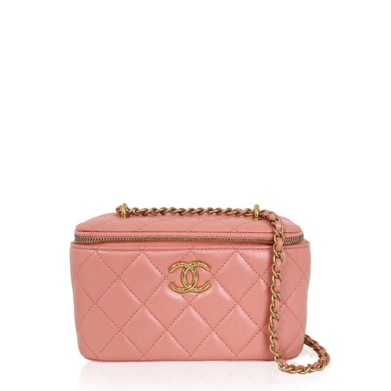 Chanel Pink quilted vanity case handbag with gold chain and logo on a white background