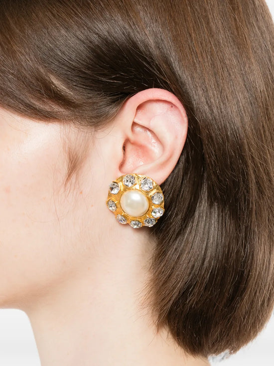 Pair of vintage 1970s Chanel gold-plated clip-on flower earrings featuring a central faux pearl cabochon surrounded by a halo of clear crystals.