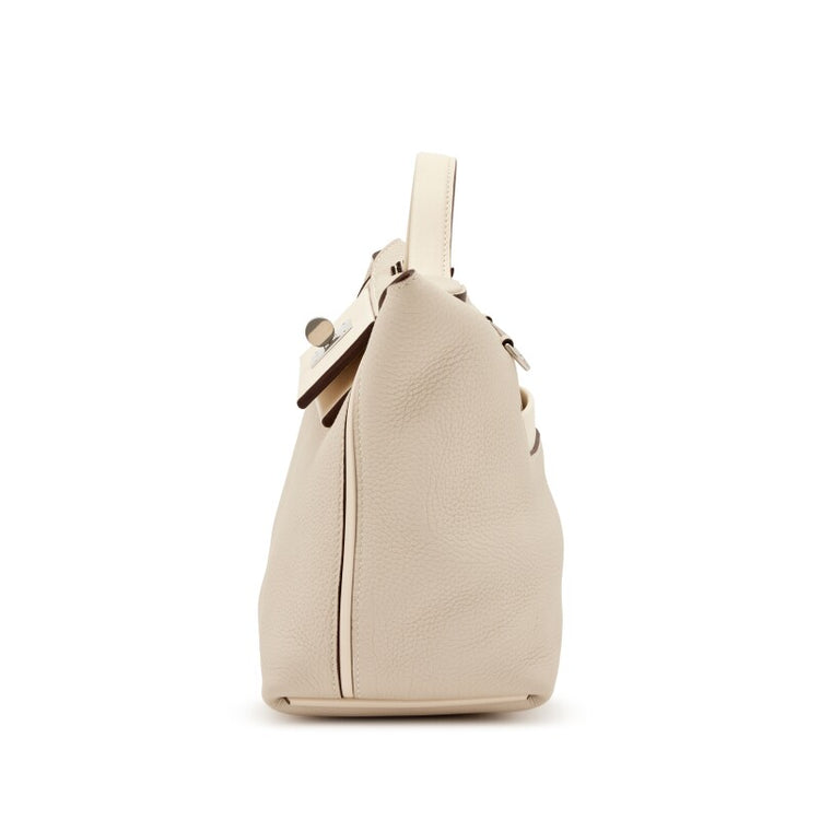 Hermès Nata Togo 24/24 tote bag in beige leather, shown from a side angle with gold hardware details.