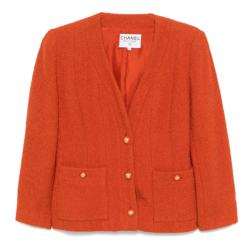 Chanel orange tweed blazer with classic tailored fit, featuring textured fabric and elegant lapel collar.