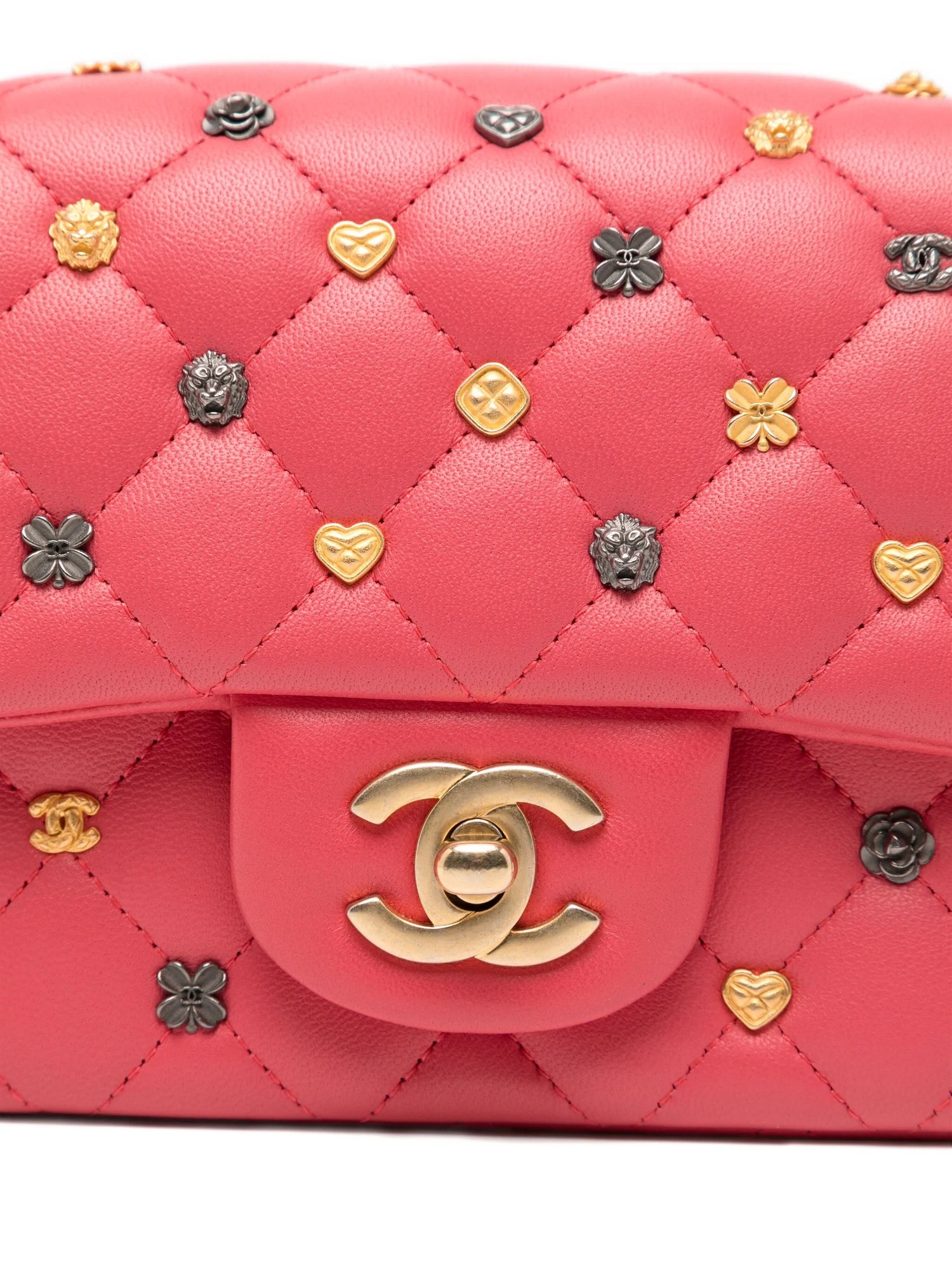 Chanel Classic Studded Flap Bag in pink quilted handbag with decorative pins and gold Chanel logo.