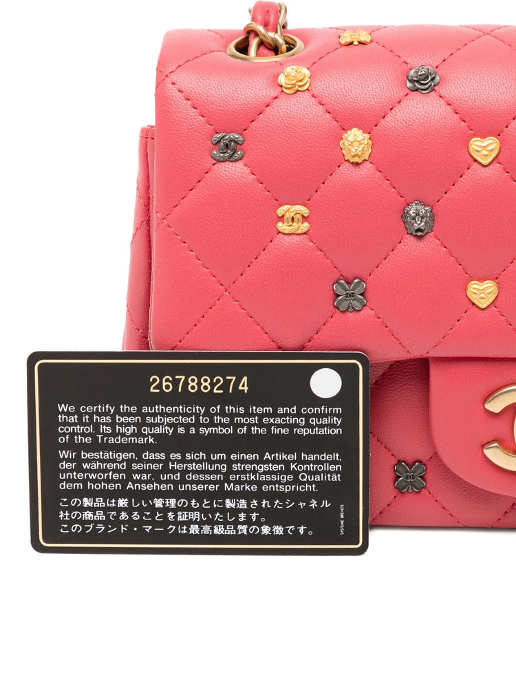 Chanel Classic Studded Flap Bag in Pink with decorative studs and a authenticity label on a white background