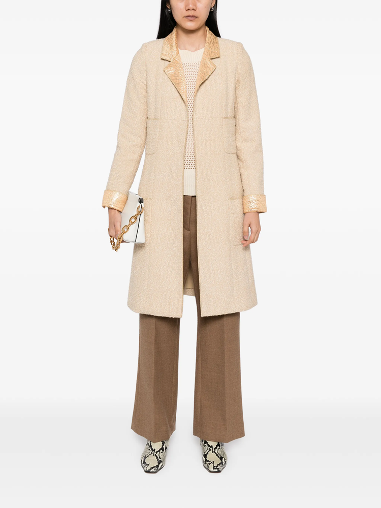 Beige wool bouclé coat with golden lamé accents, stylish Chanel coat displayed on a hanger.