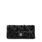 Black Chanel sequin East West Flap Bag with shoulder strap and gold hardware, showcasing its shimmering exterior and elegant design.