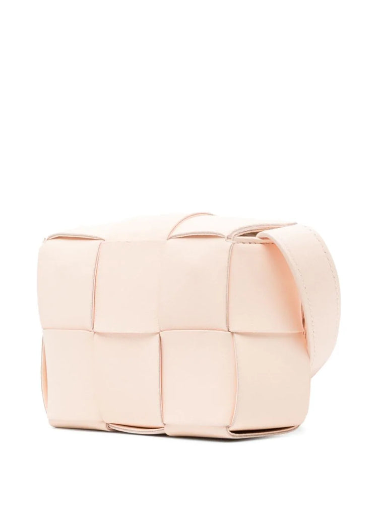 Bottega Veneta Candy Cassette Crossbody Bag in blush pink leather with oversized intrecciato weaving, structured rectangular silhouette and adjustable shoulder strap.