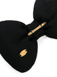 Chanel black satin bow brooch pin featuring structured oversized loops and a smooth silk-satin finish.