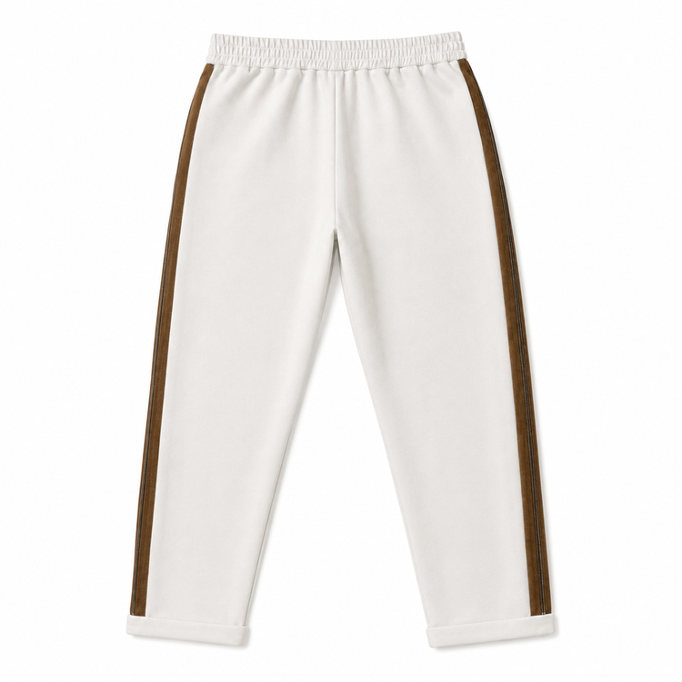 Brunello Cucinelli ivory jogger pants with elasticated drawstring waistband, brown side stripe panels, metallic trim detail, tapered leg, rolled cuffs, and relaxed tailored fit.