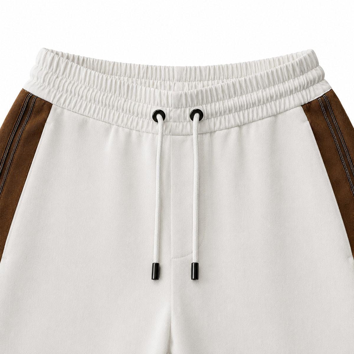 Brunello Cucinelli ivory jogger pants with elasticated drawstring waistband, brown side stripe panels, metallic trim detail, tapered leg, rolled cuffs, and relaxed tailored fit.