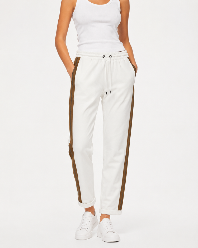 Brunello Cucinelli ivory jogger pants with elasticated drawstring waistband, brown side stripe panels, metallic trim detail, tapered leg, rolled cuffs, and relaxed tailored fit.