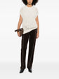 Brunello Cucinelli sleeveless knitted vest in neutral color, featuring a fitted design and ribbed armholes, styled as a top.