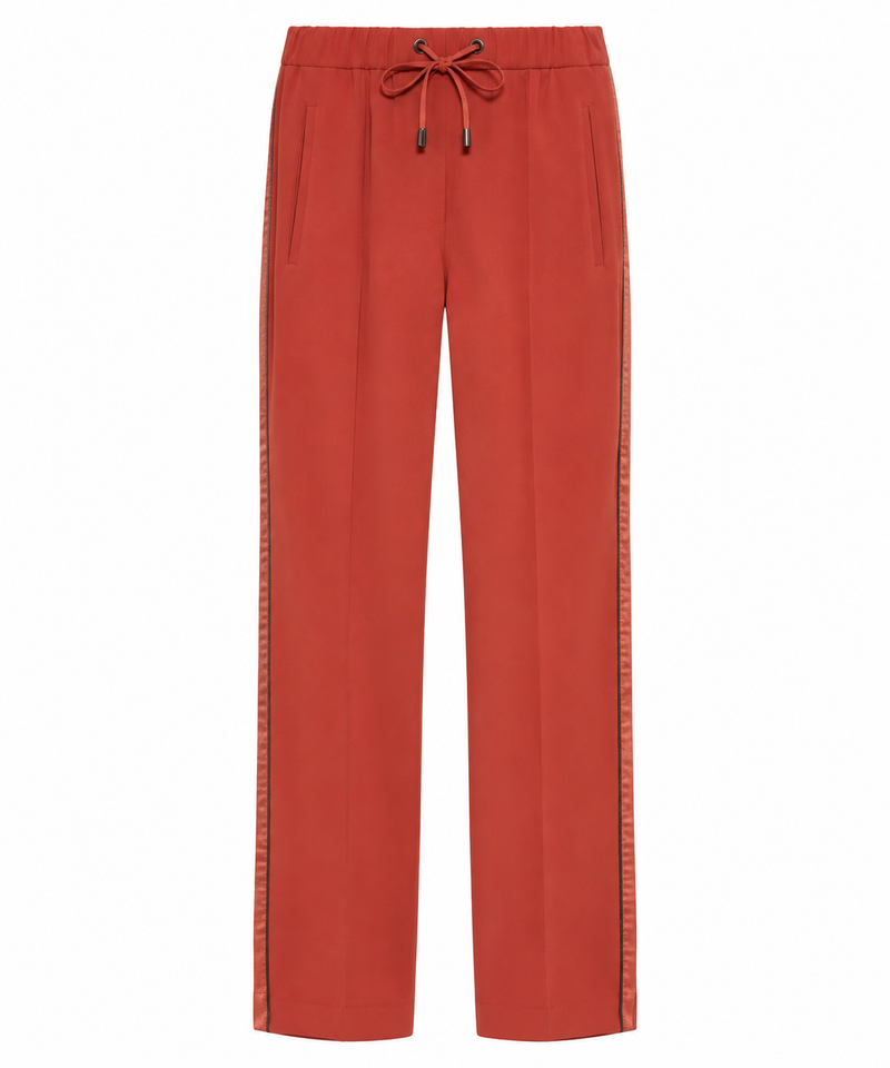 Brunello Cucinelli red drawstring trousers with relaxed fit and elastic waistband, shown hanging against a plain background.