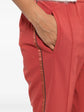 Red Brunello Cucinelli drawstring trousers with a relaxed fit, featuring adjustable waist ties and tailored fabric design.