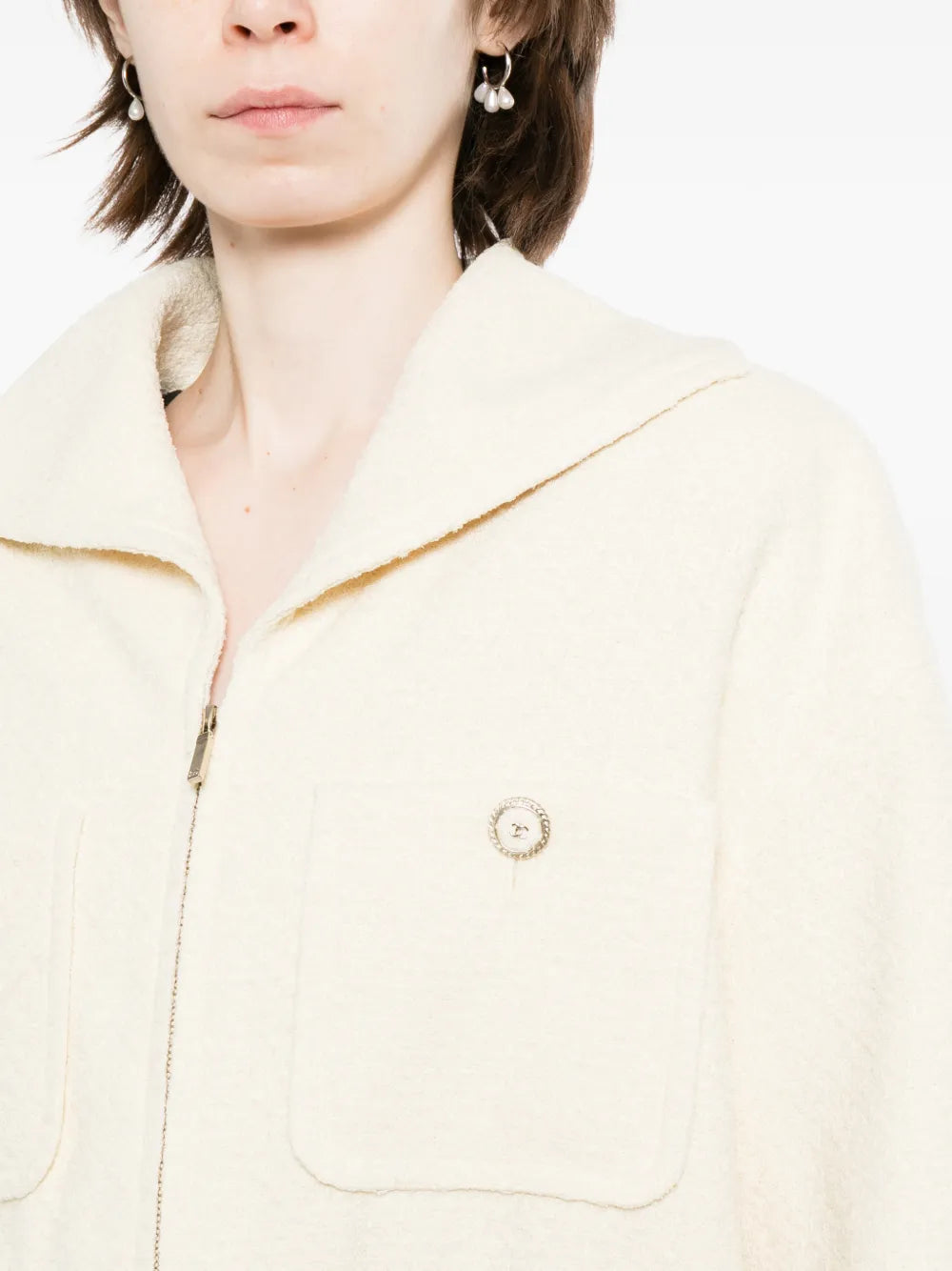 Pre-owned CHANEL tweed jacket with classic pattern, tailored fit, and elegant design, shown on a hanger.