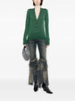 Pre-owned green CHANEL wool top with long sleeves and a classic fit, displayed on a hanger.