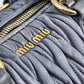 Miu Miu Matelassé tote bag with quilted design and silver hardware, shown in a close-up detail image.