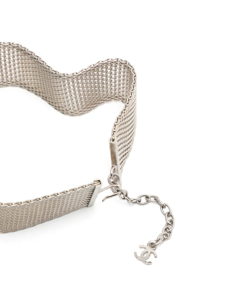 Vintage Chanel silver-plated mesh choker collar featuring a mother-of-pearl camellia flower centerpiece and adjustable extension chain with a mini CC charm.
