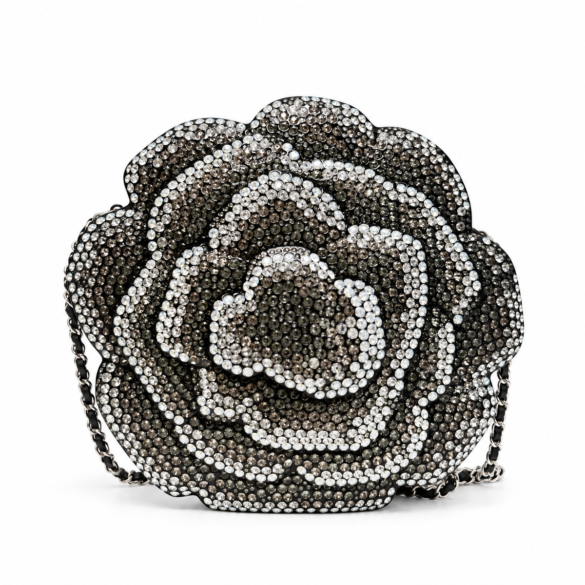 Chanel Camellia Minaudière evening clutch bag with floral design and elegant gold clasp on a black background.
