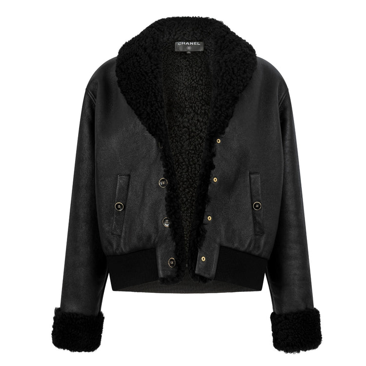 Back view of a black leather shearling Chanel coat, showcasing the luxurious texture and stylish design.