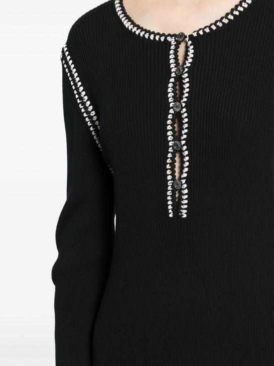 Chanel 2002 black ribbed cotton mini dress with round neckline, long sleeves, contrast white looped trim and decorative front button detailing.