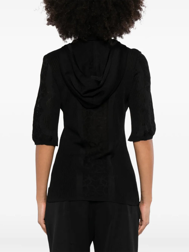 Black Chanel lace-panel polo top with hood, featuring intricate lace details and a stylish, casual design.