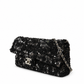 Black Chanel sequin east-west flap shoulder bag with silver chain strap and elegant design.