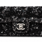 Black Chanel sequin east-west flap shoulder bag with silver hardware and chain strap, stylish and elegant for evening wear.