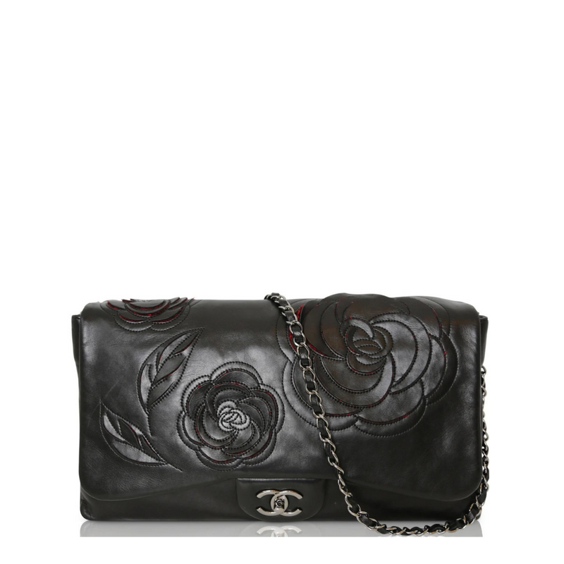 Black lambskin Chanel Camellia Runway Flap Bag with shoulder strap and signature floral detail, stylish and luxurious.
