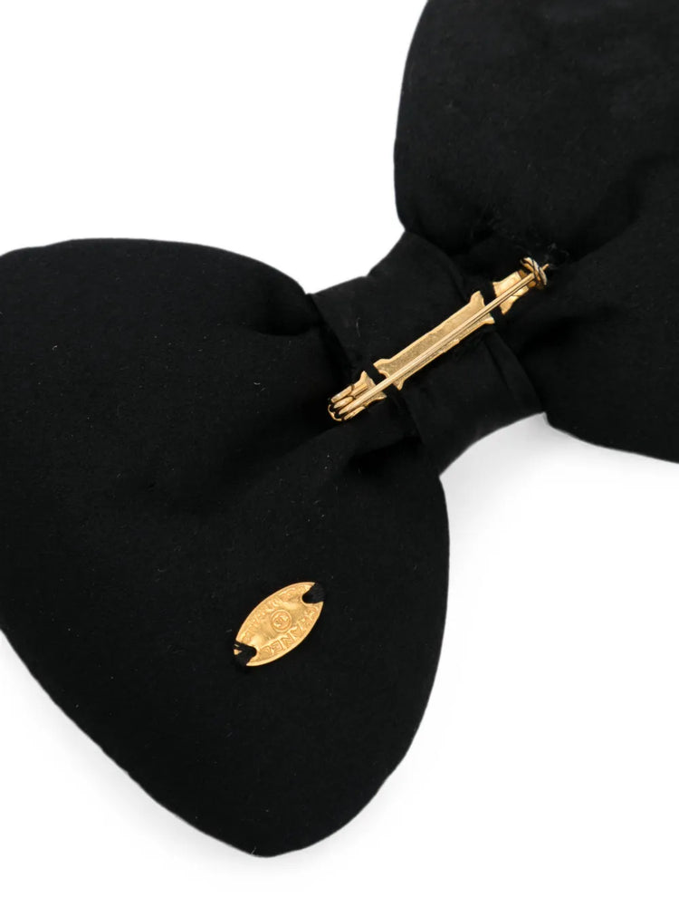 Chanel satin bow brooch featuring a elegant bow design with a smooth satin finish, perfect for accessorizing and adding sophistication.
