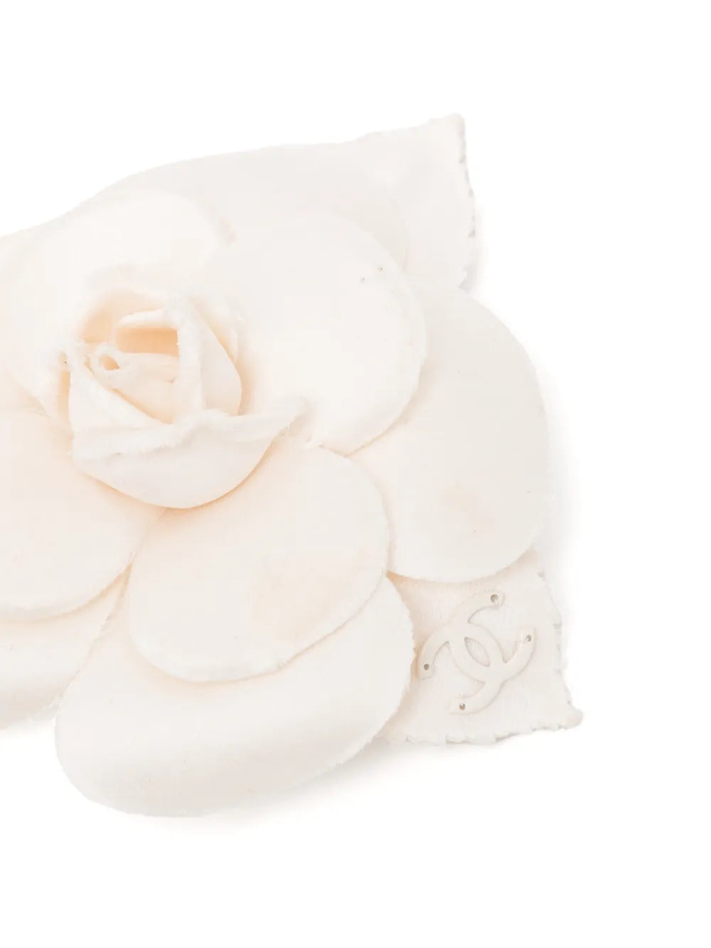 Chanel off-white fabric camellia flower brooch pin featuring layered petals and a leaf accent with a subtle cream CC logo.