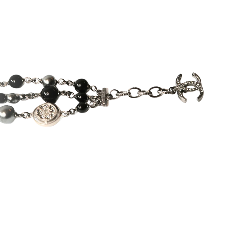 Chanel CC charm beaded bracelet with gold-tone beads and signature logo charm on a delicate chain.