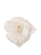 Chanel off-white fabric camellia flower brooch pin featuring layered petals and a leaf accent with a subtle cream CC logo.