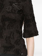 Close-up of ripped detailing on Chanel black cotton top