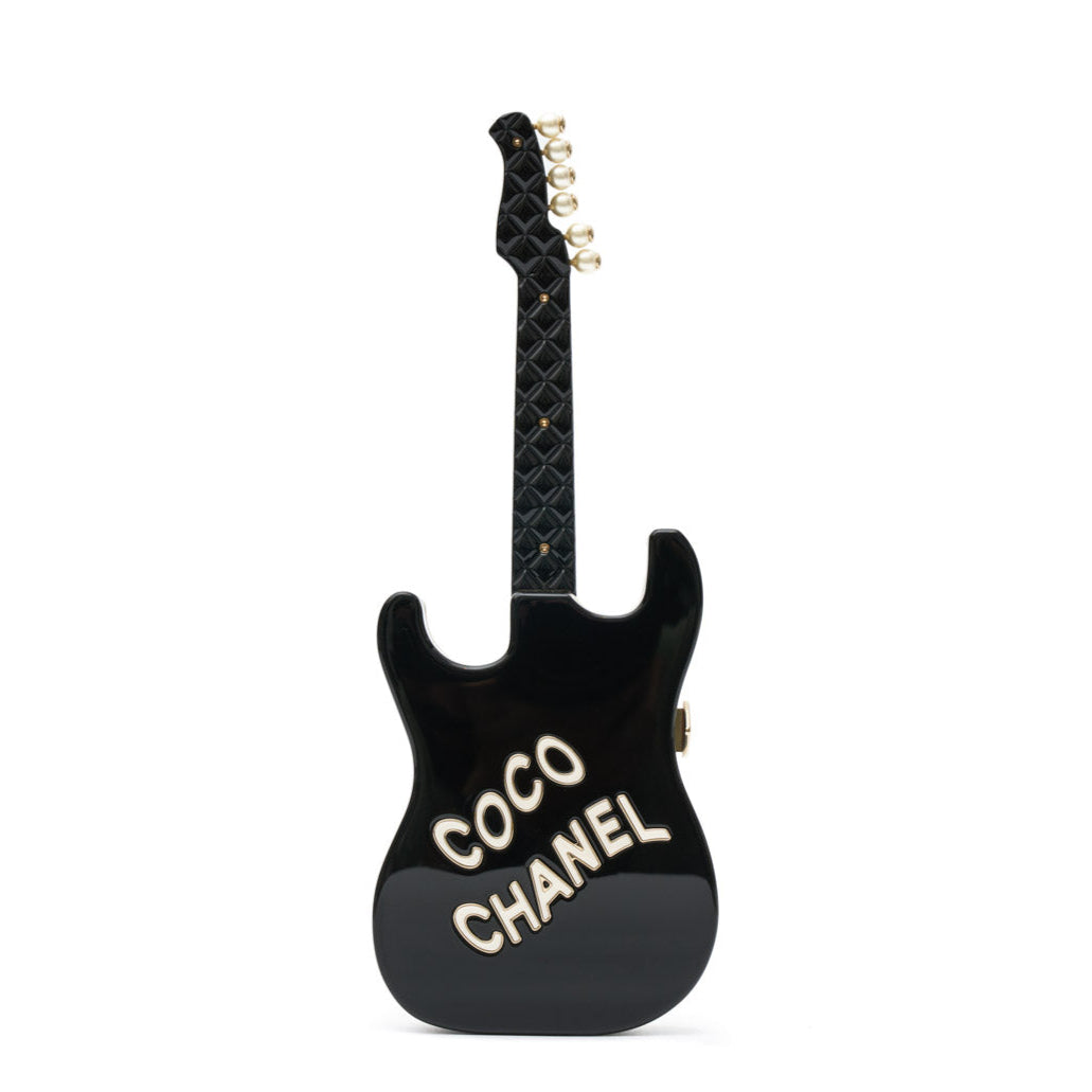 Chanel Collectible Guitar Minaudière Clutch Bag in white and black plexiglass with guitar-shaped design, CC logo detail, sticker-style motifs, pearl embellishment, gold-tone hardware, and chain shoulder strap.