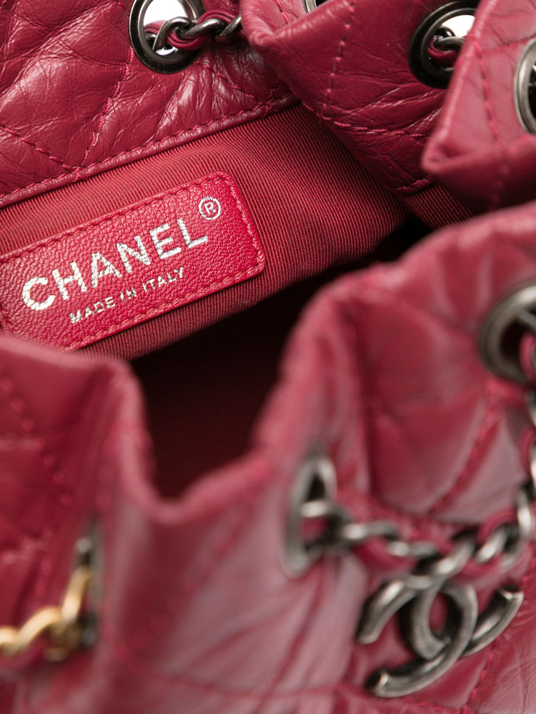 Chanel Gabrielle red backpack, side view on plain background