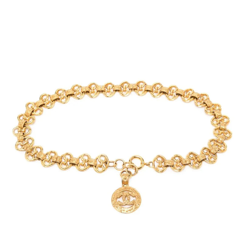 Gold vintage Chanel belt with classic design and buckle, showcasing elegant, high-quality leather and timeless style.