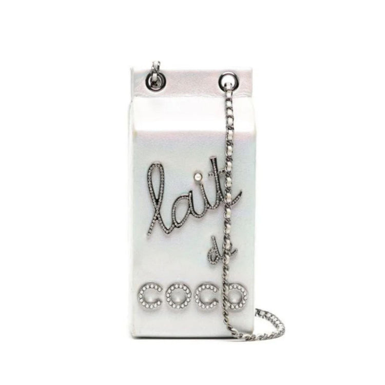 Chanel Lait de Coco Milk Carton Bag in metallic silver with structured carton shape, top handle, chain strap, pearl-style lettering and novelty runway design.