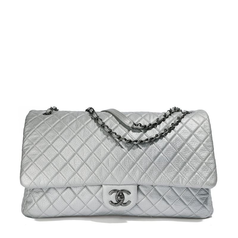 Chanel Metallic silver XXL airline travel flap bag by Rewind Vintage Affairs, showing its shiny surface and spacious design.