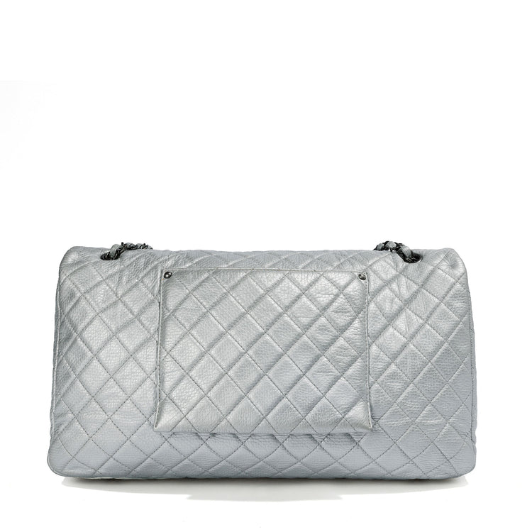 Chanel Metallic silver XXL airline travel flap bag by Rewind Vintage Affairs, showing its shiny surface and spacious design.