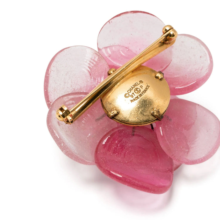 Pink Camellia Chanel brooch with delicate flower design, featuring soft pink petals and subtle gold accents.